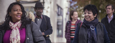 Diverse group of people in winter clothes walking down a street
