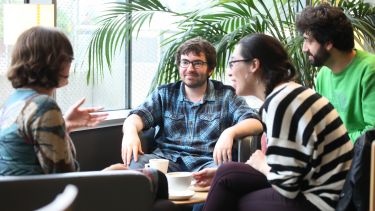 Postgraduate philosophy students sitting around coffee table