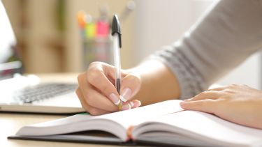 Student writing in a book