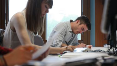 Postgraduate students writing and concentrating