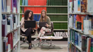 Students conducting research in the library.