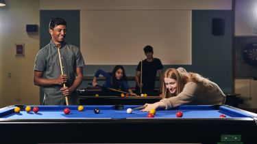 Pool table - two students playing