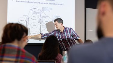 An academic delivering a lecture in the School of Health and Related Research. 