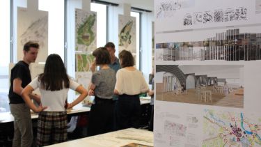 Students gather around concept art in the Department of Landscape Architecture.