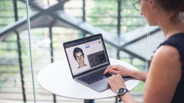 Dr Heidi Christensen sitting at a computer demonstrating the digital doctor