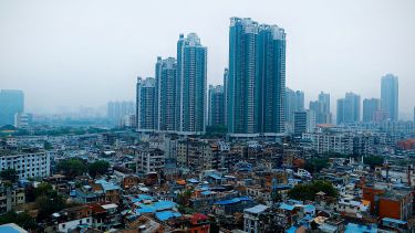 Cityscape with skyscrapers in background and slums in foreground