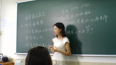 Chinese Mandarin teacher in front of a blackboard in a classroom