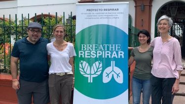 Breathe/Respirar banner with researchers gathered around it