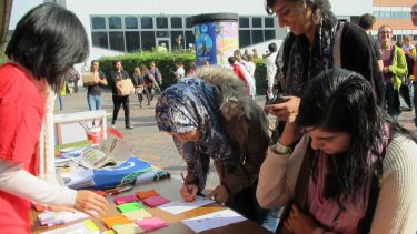 People at a table outside of the Students' Union signing up to a course