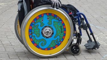 Wheelchair with colourful design on wheels