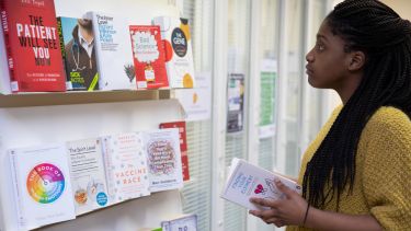 Woman looking through Statistics books