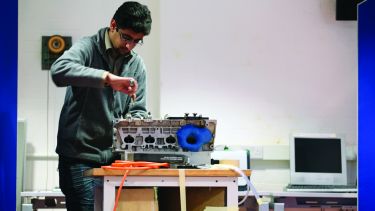 Mechanical engineering student using a screwdriver