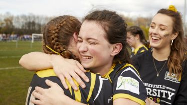 Women's football players hugging