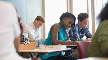 A group of students writing in a classroom