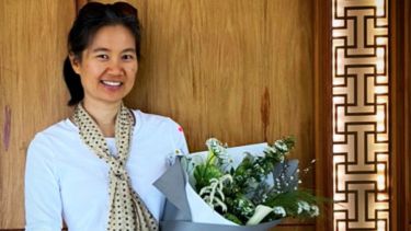 PhD Student Kim Netiparatanakul holding flowers