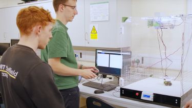 Photo of students operating their robot in a box