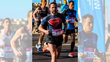 Neil Jones running in a Superman top