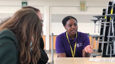 A student ambassador talking to a group of young people on a widening access programme.