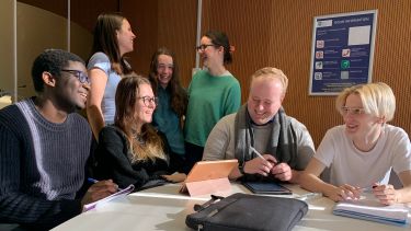 Group of students in one of Jessop West Hub Rooms. They look at each other and laugh