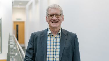 Richard Bruce wearing a checked shirt and a jacket.