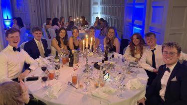 PolSoc members dressed in their best and seated at a fancy dinner table for the PolSoc Ball 