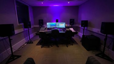 Music studio with speakers and desk in the middle