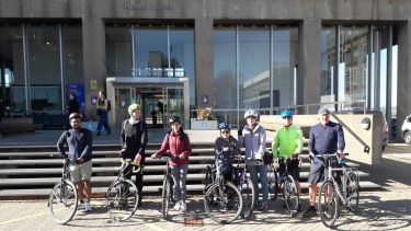 Riders standing in front of the Arts Tower with their bikes for the guided ride to the AMRC in April 2023
