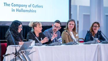 Five panel members sit in discussion at the Productivity Puzzle Event