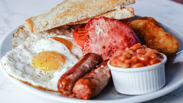 A full English breakfast with bacon, sausages, eggs, beans, toast and hash browns