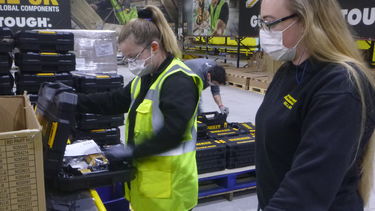 Lucy Hattersley, an apprentice at the AMRC Training Centre, looking in a tool box alongside a colleague