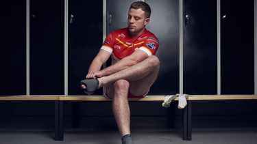 Rugby player Blake Broadbent putting his sock on 