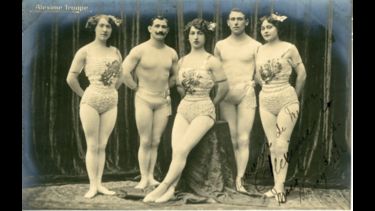 	 Photographic postcard of the Alexime Troupe in costume. .  French flying trapeze performers, led by Alphonse Bernier who was trained by Cesari.  With Alfred Clarke's circus, 1914, in Colombo, consisting of Mr and Mrs Alexime with their assistant Miss Marthe Hamel.  Mrs Victoria Alexime also gave an equestrian performance. Noted at the Great Continental Circus, Crystal Palace, London, 1924-25, when the lady executed a triple somersault in her descent.  At T.E. Read's Gt. Yarmouth Hippodrome, in 1926.  Back