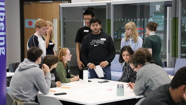 A group of students in The Wave sat in a group completing a challenge 