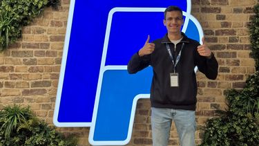 Student with thumbs up in an office building