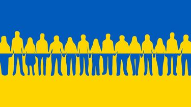 Silhouettes of people holding hands against a Ukrainian flag.