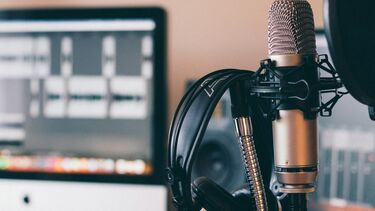 a microphone in the foreground and monitor in the background