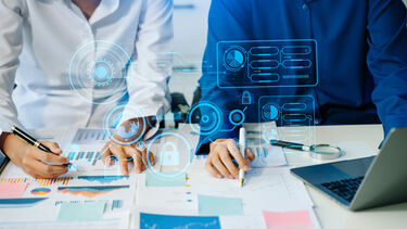 Two people looking at data on a table.