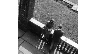 black and white photo of two students talking on campus, taken by Bill Walsh