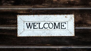 A welcome sign attached to a wooden wall