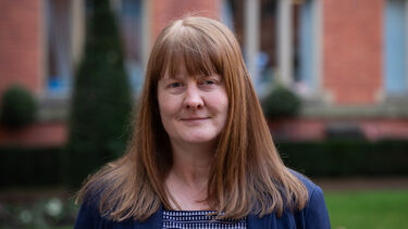 Portrait of a person smiling, with long straight auburn hair