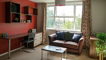 Shore Court living room with a sofa, tables and desks. 