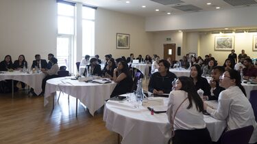 A room of students sat around tables in their teams.