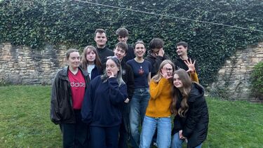 Group of about 1 students with warms clothes on in a beer garden