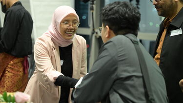 Two Sheffield alumni shaking hands during the Indonesia alumni event.