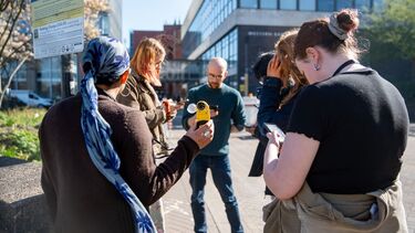 Urban studies students taking wind speed measurements using an anemometer.