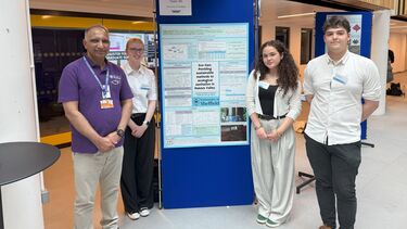 Engineering students presenting their work on a poster board