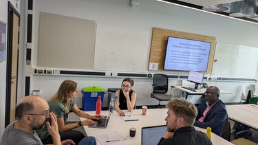 four attendees sit around a table for discussion