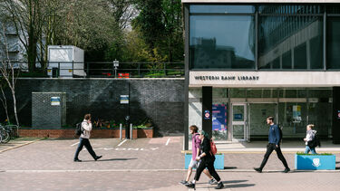 A view of the entrance to the Western Bank Library with students walking past