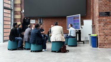 Researchers sat in a circle listening to a presentation