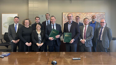A group of staff from both the Universities of Sheffield and Alberta stand in a boardroom and face the camera, smiling.
